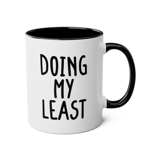 White mug with black interior and handle, featuring the text 'DOING MY LEAST'.